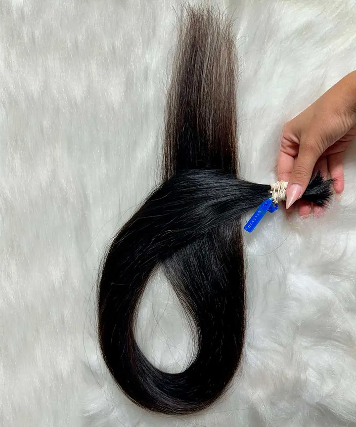 Cabelo brasileiro ondulado natural de 85 cm, segurado pela mão